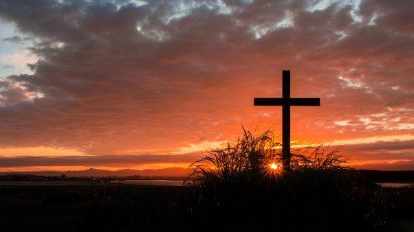 Cross on a hill as the morning sun comes up for the day.