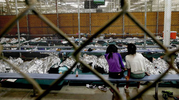 Two girls watch a World Cup match in the U.S. Customs and Border Protection Nogales Placement Center in Brownsville, Texas.