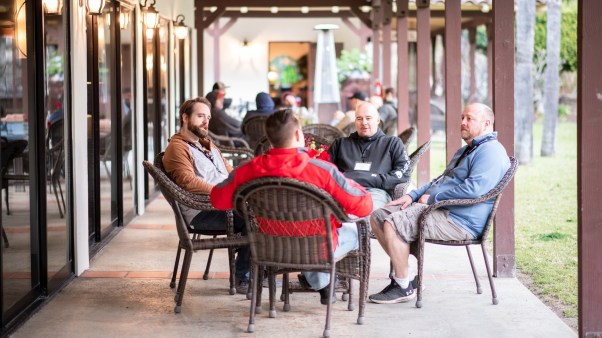 Group of men discussing around a table.