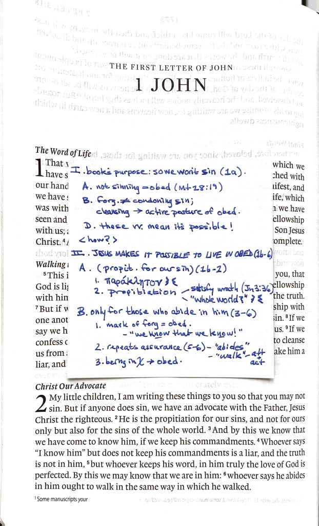 A photo of the first page of 1 John with a sticky note on the page that contains notes
