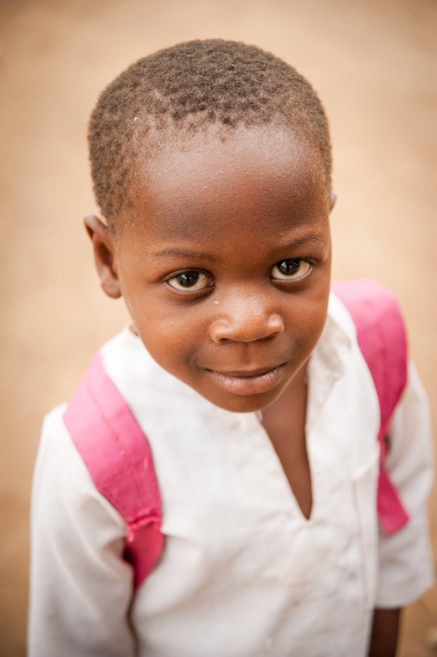 A young boy from a surrounding village who is attending school on the base.