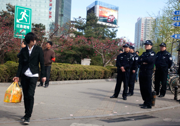 Chinese police officers watch and prepare to detain worshipers near a building where Shouwang house church leaders told parishioners to meet in Beijing, China, Sunday, April 10, 2011.