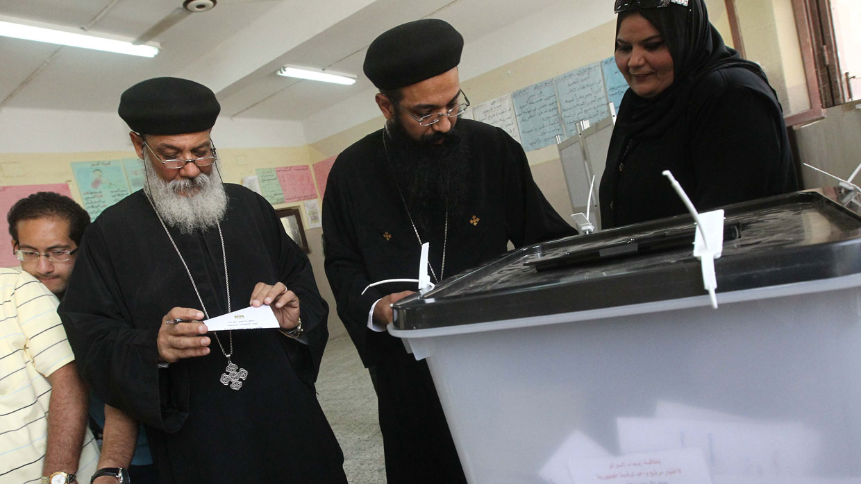 Egyptian Coptic priests wait to cast vote.