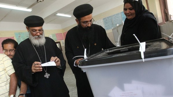 Egyptian Coptic priests wait to cast vote.