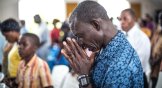 A Christian prays for the people who died due to Ebola, on a ritual in St. Joseph Parish Catholic Church in Monrovia, Liberia on 12 October, 2014.