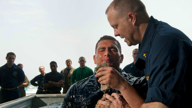 Navy chaplain baptizes sailor aboard USS Carl Vinson.