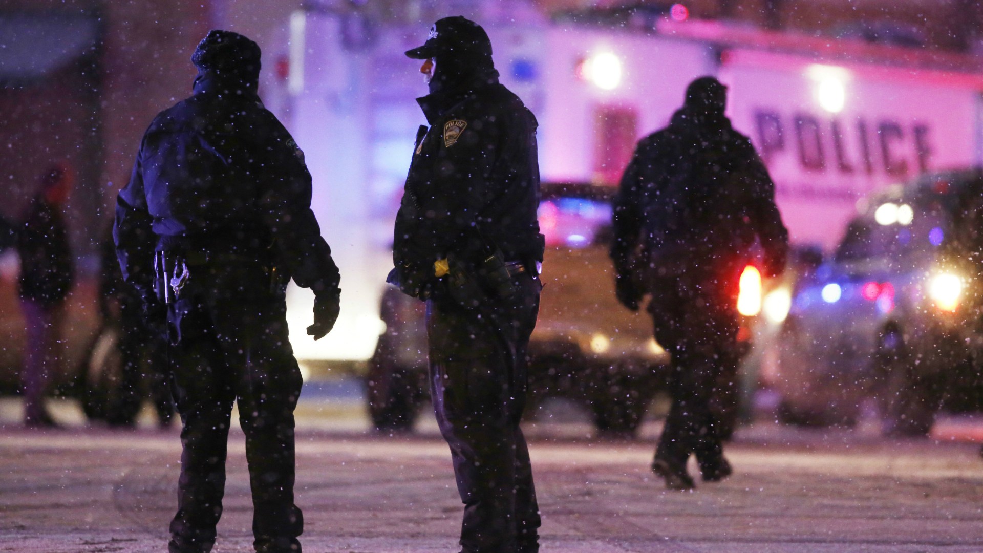 Police confer at an intersection near the scene of a shooting at a Planned Parenthood clinic Friday, Nov. 27, 2015, in Colorado Springs, Colo.