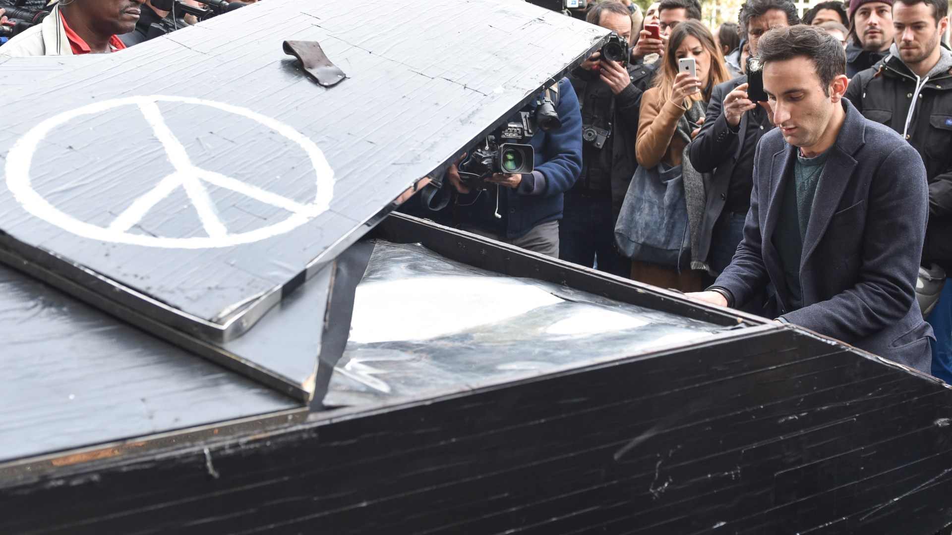 Pianist Davide Martello plays the song 'Imagine' in front of the music venue 'Bataclan' in Paris, France, 14 November 2015.