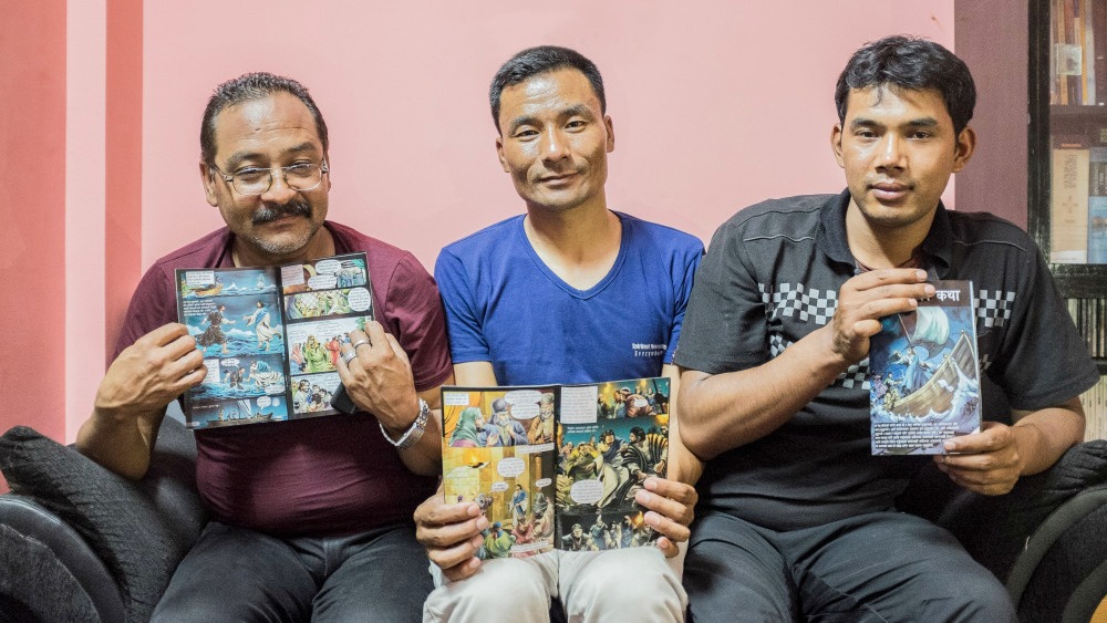 Three of the released Christians show the booklet that led to charges against them.