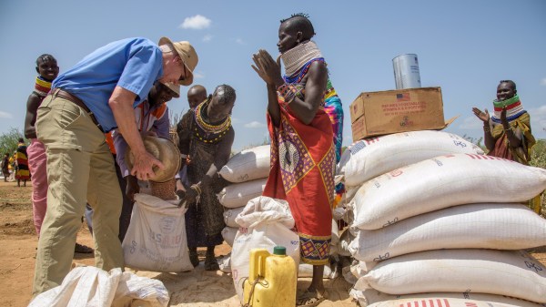 World Vision president Richard Stearns helps Turkana women in Kenya divide their share of maize.