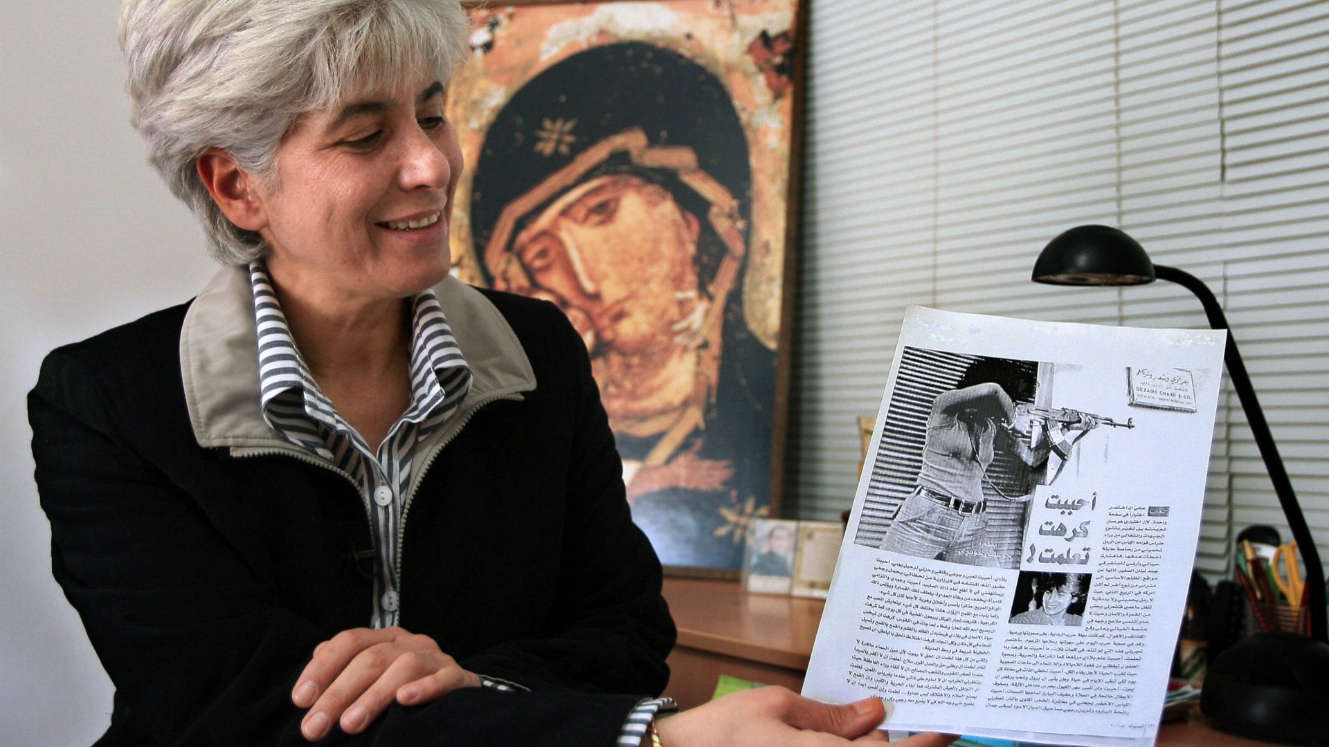 Jocelyne Khoueiry, a former Christian Maronite Phalange party fighter, looks at an iconic picture of herself holding a gun during fighting in downtown Beirut in 1975 at the height of Lebanon's civil war.