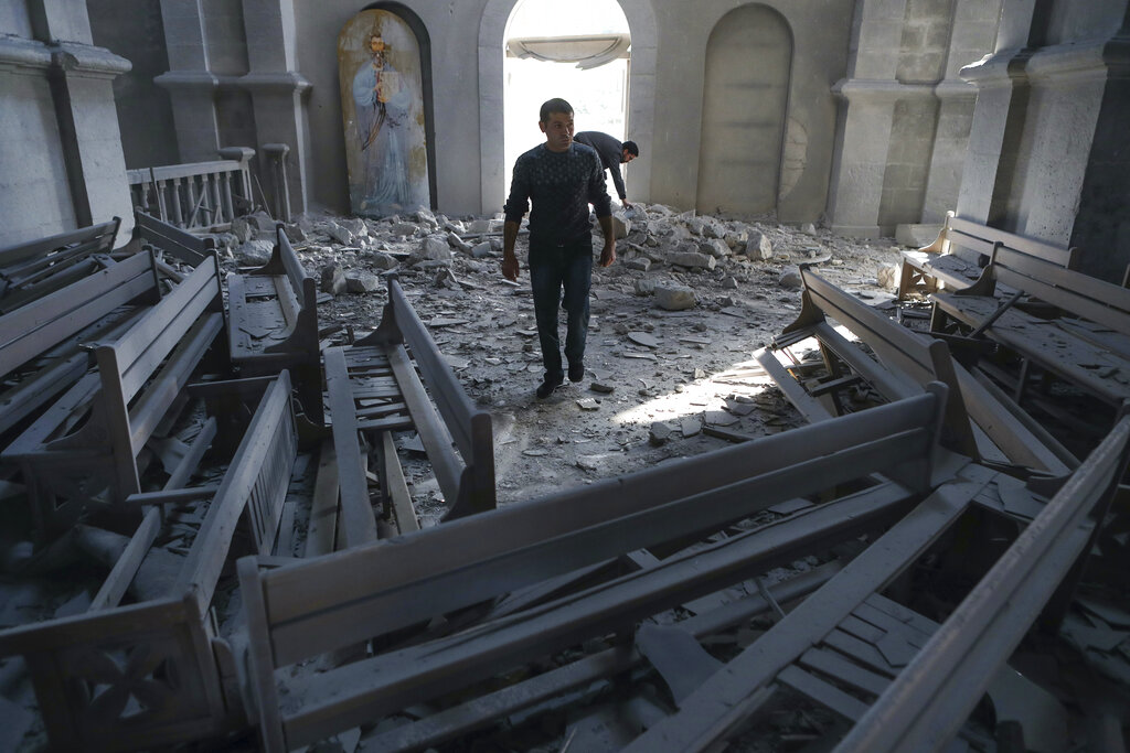 A man walks in rubbles of the Ghazanchetsots (Holy Saviour) Cathedral in the city of Shusha, some 15 kilometers from the Nagorno-Karabakh province's capital Stepanakert on October 8.