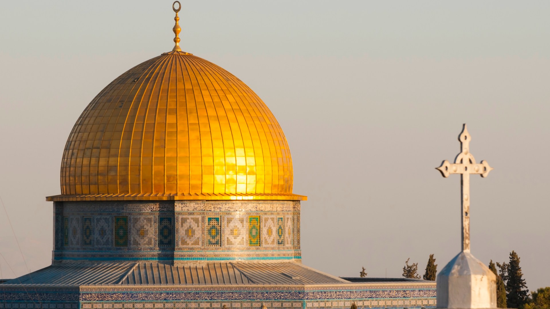 The Dome of the Rock, an Islamic shrine, and the cross of a church in the old city of Jerusalem.