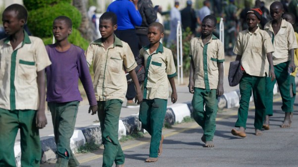 A group of Nigerian schoolboys are escorted December 18 by military and officials in Katsina following their release after they were kidnapped last week.