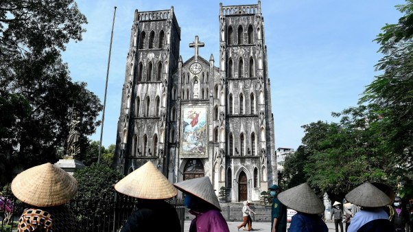 Vietnamese residents wearing face masks practice social distancing as they stand in a queue for free rice at St. Joseph's cathedral in the old quarters of Hanoi on April 27, 2020.