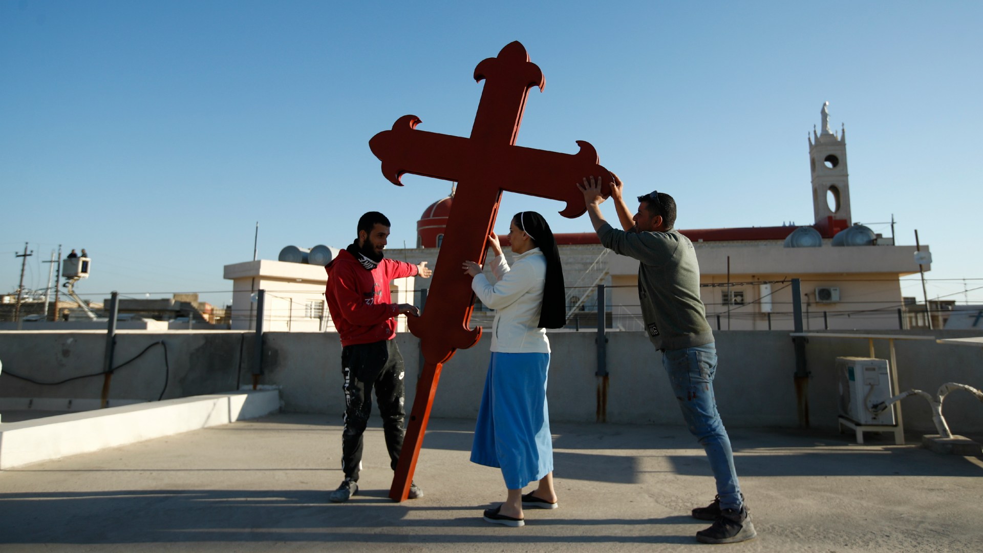Iraqi Christians place a cross on a church in Qaraqosh on February 22 in advance of Pope Francis' visit to Iraq next month.