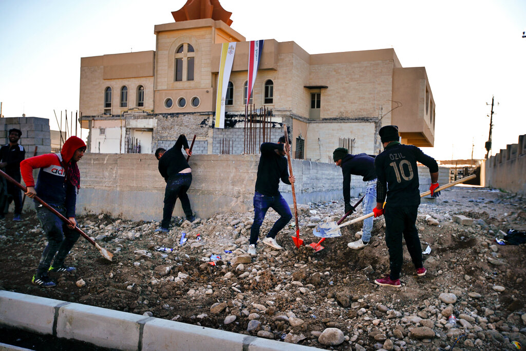 People fix a street destroyed during clashes against Islamic State militants in Qaraqosh, Iraq, on February 23.