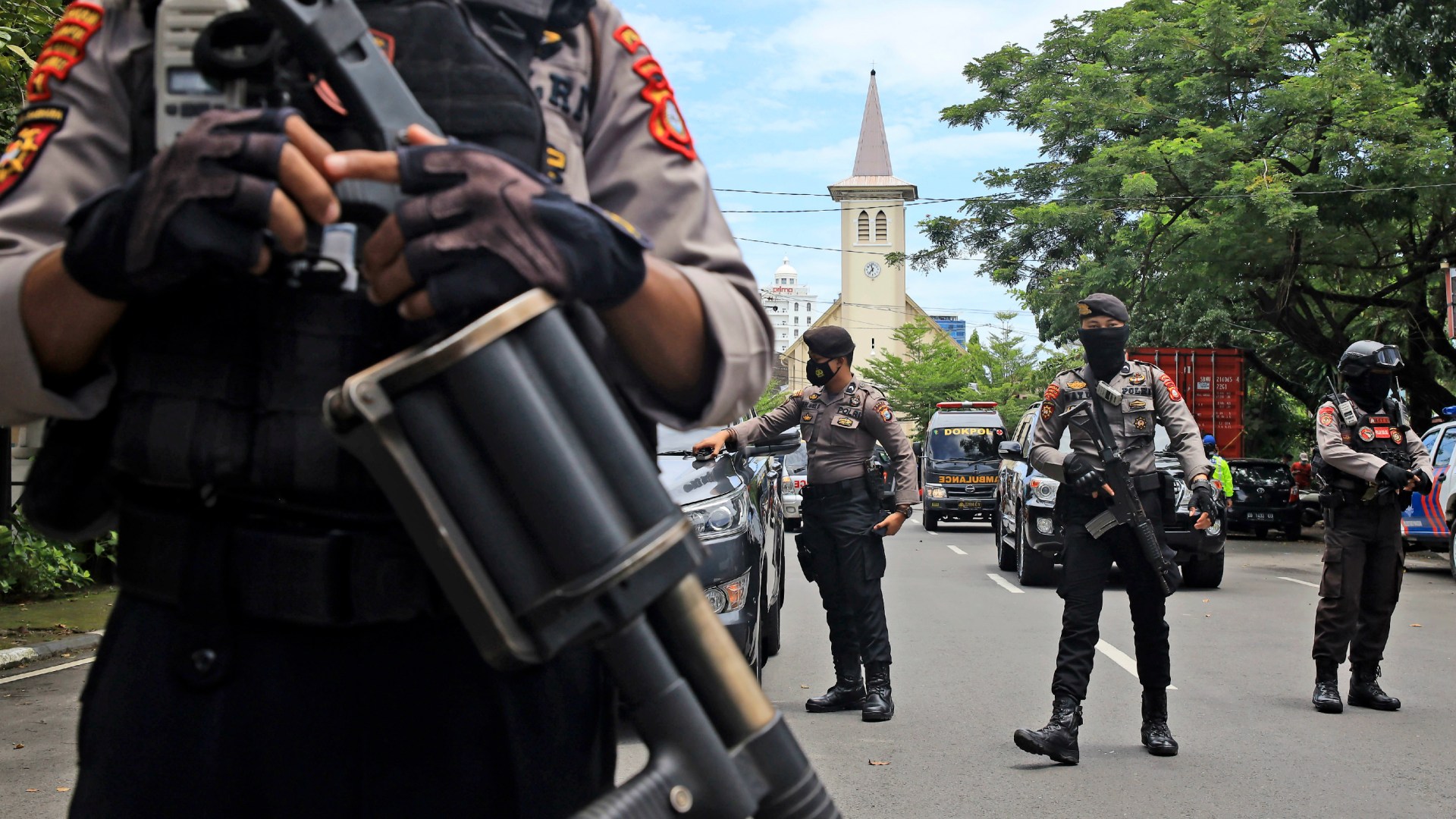Indonesian police officers in Makassar stand guard near a Catholic church where an explosion went off on Palm Sunday in South Sulawesi on March 28, 2021.