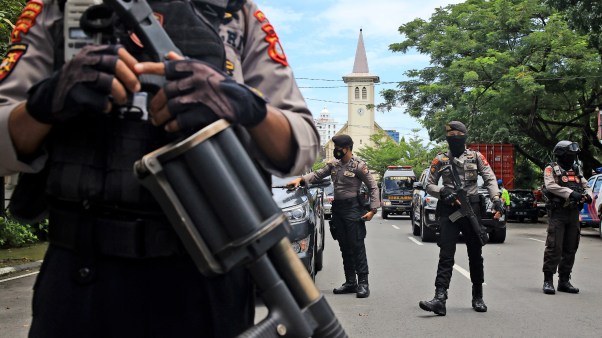 Indonesian police officers in Makassar stand guard near a Catholic church where an explosion went off on Palm Sunday in South Sulawesi on March 28, 2021.