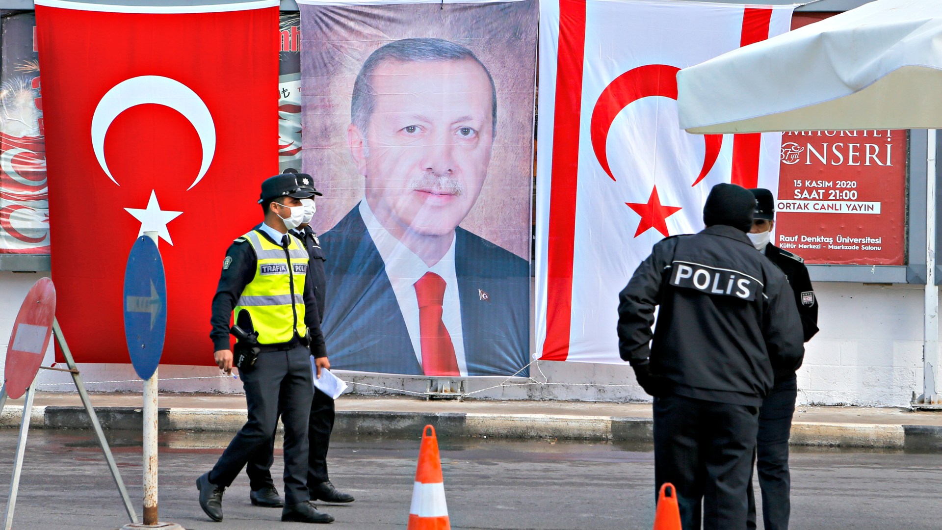 Turkish Cypriot police stand before a portrait of Turkish President Recep Tayyip Erdogan on November 15, 2020 in the disputed coastal quarter of Varosha in Famagusta, during his state visit to the self-proclaimed Turkish Republic of North Cyprus.