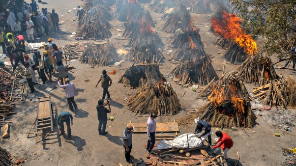 Multiple funeral pyres of Indian victims of COVID-19 burn in a New Delhi area converted for mass cremation on April 24.