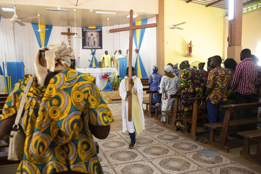 An altar boy carries a cross as Noel Henri Zongo, priest at the Church of the Sangoulé Lamizana military camp in Ouagadougou, Burkina Faso, celebrates Mass on April 11. Just seven chaplains are charged with spiritually advising some 11,000 soldiers and helping maintain their morale.