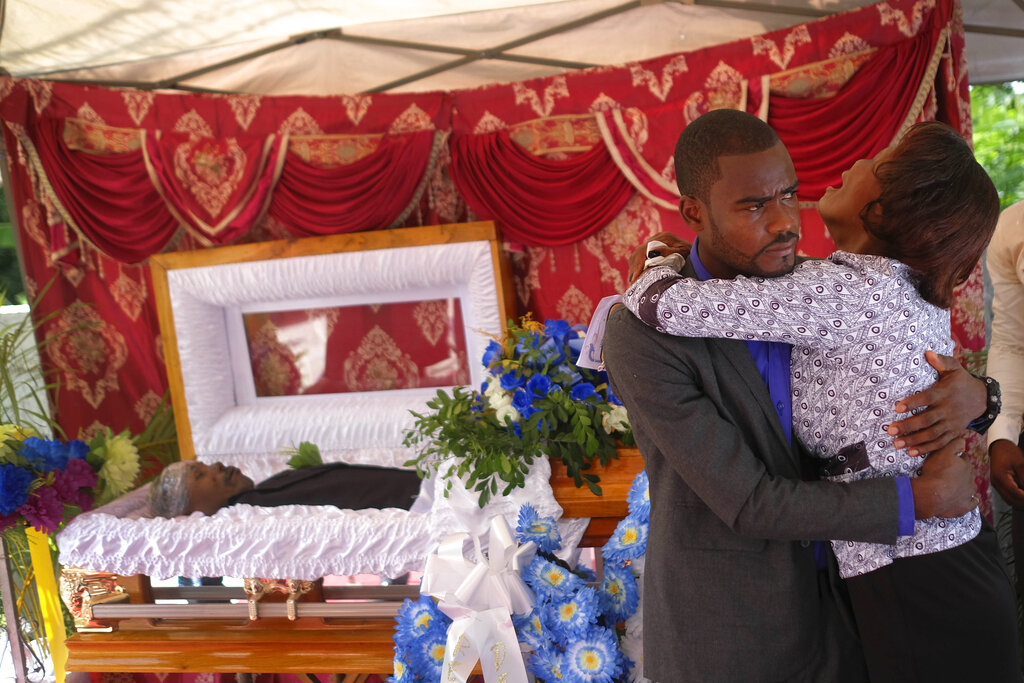 The son and mother of Baptist church minister Andre Tessono, who was killed during the 7.2 magnitude earthquake that hit the area eight days ago, mourn during his funeral in the Picot neighborhood in Les Cayes, Haiti, Sunday, Aug. 22, 2021.