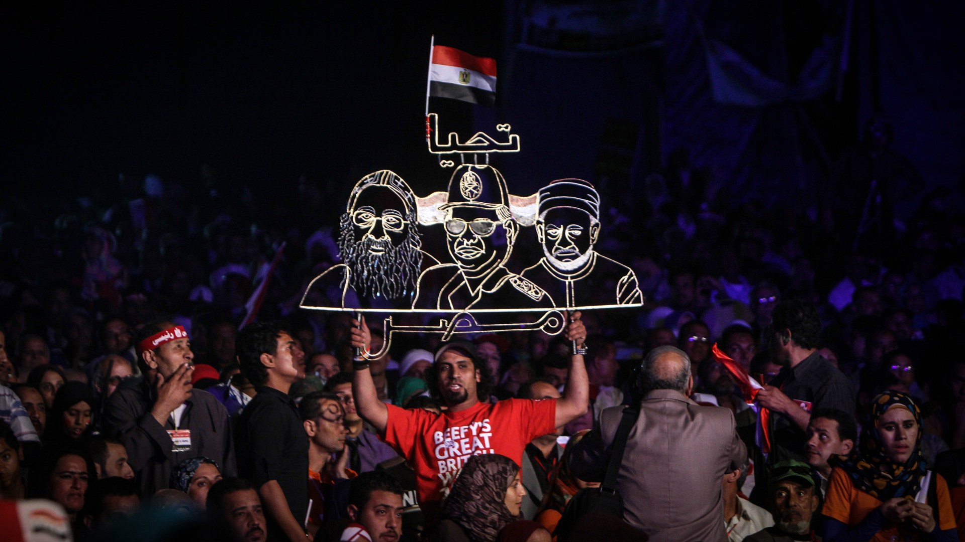 A neon sign portraying now President Abdel Fattah al-Sisi (center) between Coptic Pope Tawadros II (left) and Grand Imam of al-Azhar Shiekh Ahmed el-Tayeb (right) during a rally in Cairo in May 2014.