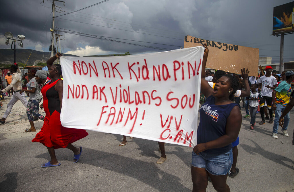 Haitian protesters carry a banner with a message that reads in Creole: "No to kidnappings, no to violence against women! Long live Christian Aid Ministries," demanding the release of kidnapped missionaries, in Titanyen, north of Port-au-Prince, Haiti, on Tuesday, October 19, 2021.