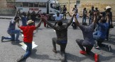 Haitians kneel outside the Justice Ministry to demand the resignation of Minister Liszt Quitel to protest kidnappings in Port-au-Prince, Haiti, on October 26, 2021.