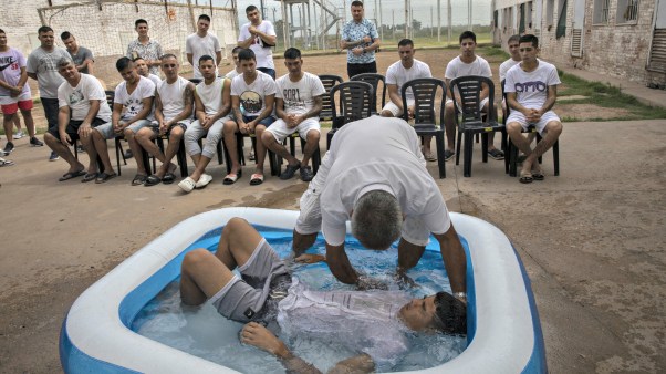 Ruben Munoz, an evangelical pastor from the church Puerta del Cielo, or "Heaven's Door," who served two years in prison for robbery, baptizes an inmate in a kiddie pool, at an evangelical cellblock inside Penal Unit N11 in Pinero, Santa Fe province, Argentina on December 11, 2021.
