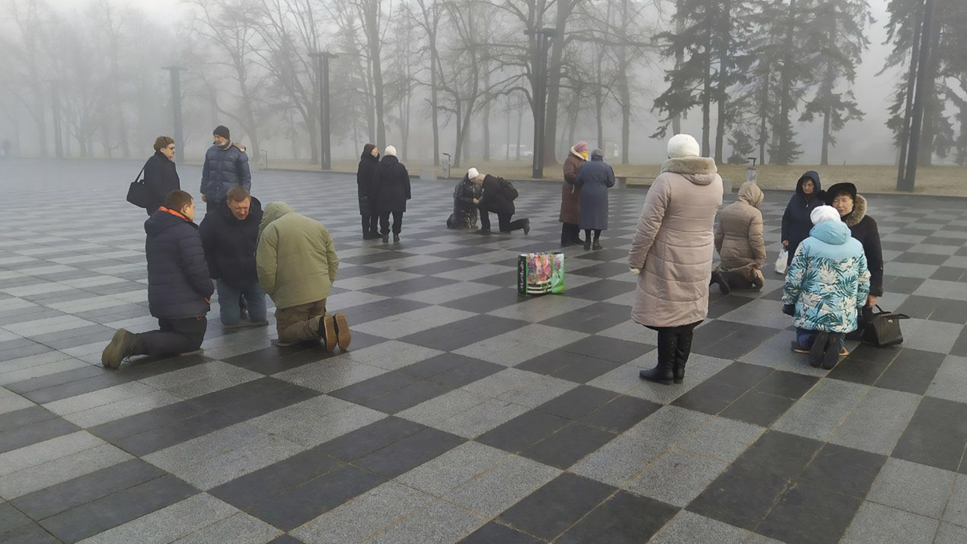 Ukranians praying in the central square of Kharkiv, Ukraine.