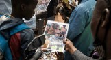 A young boy looks at a poster of lieutenant-colonel Paul-Henri Sandaogo Damiba, new strongman and head of the junta, outside the Grand Mosque of Ouagadougou after Friday prayers on January 28, 2022.