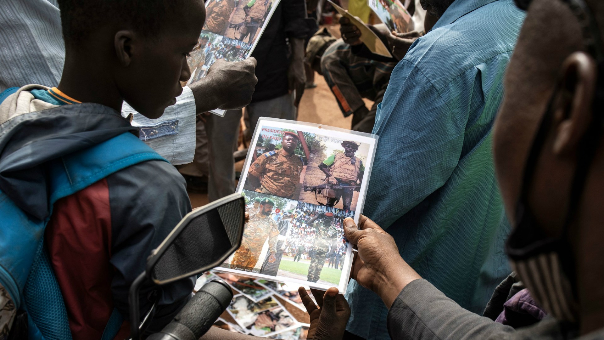 A young boy looks at a poster of lieutenant-colonel Paul-Henri Sandaogo Damiba, new strongman and head of the junta, outside the Grand Mosque of Ouagadougou after Friday prayers on January 28, 2022.
