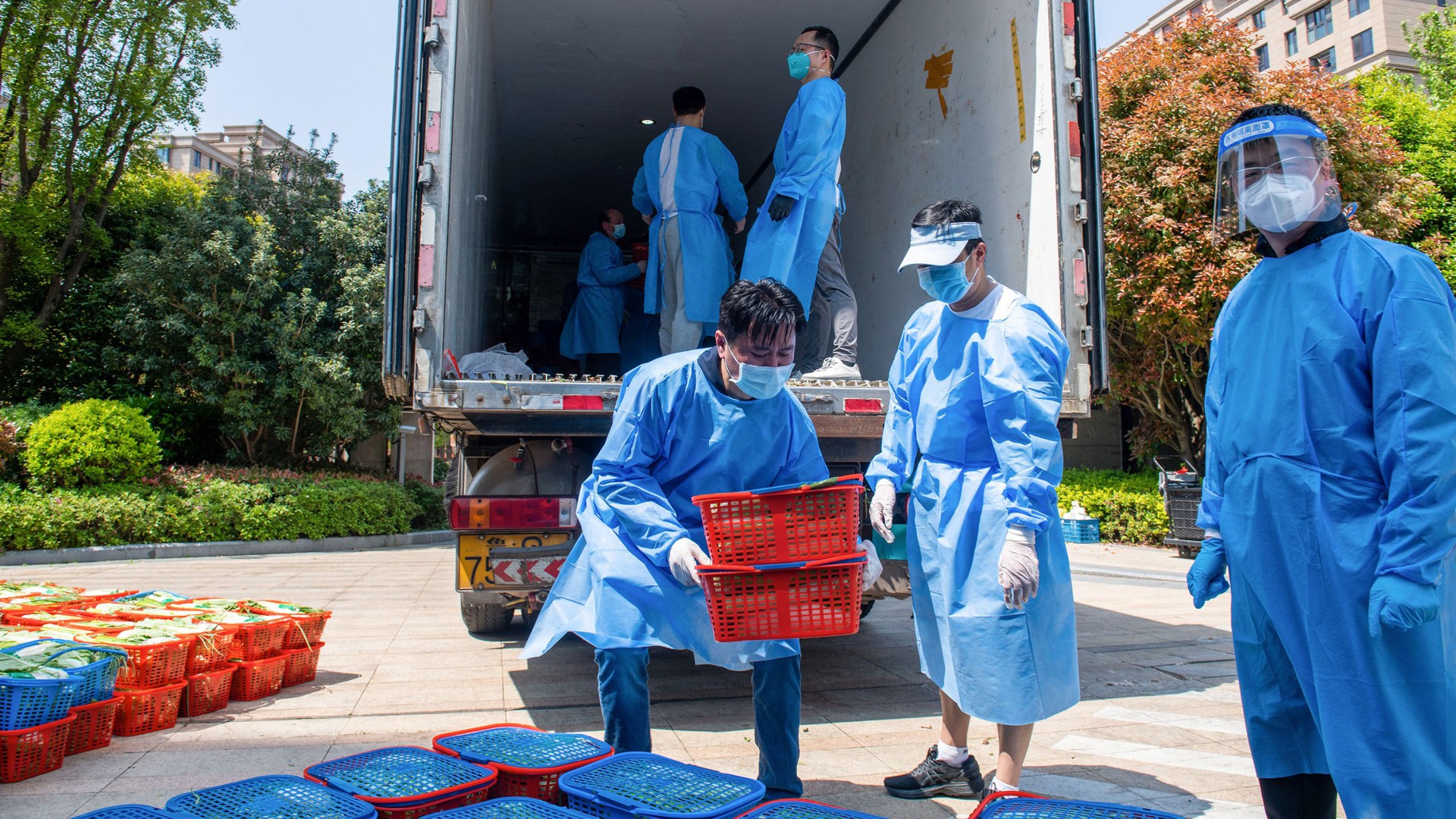Community volunteers deliver vegetables to be distributed to residents in a compound during a Covid-19 lockdown in Shanghai on April 12, 2022.