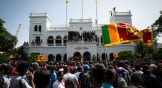 Sri Lankan protesters wave flags and chant slogans after taking control of Prime Minister Ranil Wickremesinghe's office compound amid the ongoing economic crisis on July 13, 2022 in Colombo.