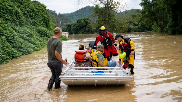 A rescue team from the Jackson Fire Department assists people out of floodwaters downtown in Jackson, Kentucky.