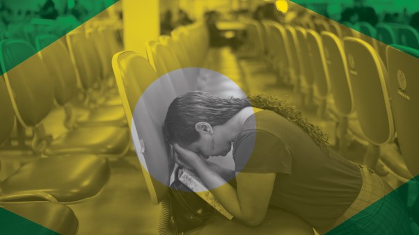 An evangelical woman kneels in prayer at a megachurch in Brazil.