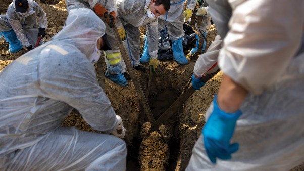 Rescue workers and forensic police exhume bodies from unidentified graves in Izium, Ukraine