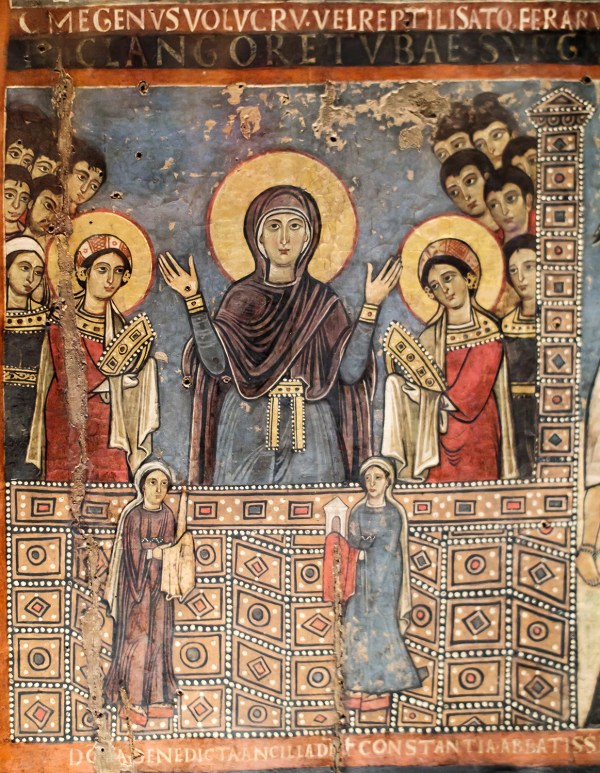 Mary lifts her arms in the orans pose in the Vatican museum. The white maniple at her waist indicates a clerical rank. Flanked by saints, she appears to be exhorting the two women below her. The two were probably benefactors of the church. Rome — 12th century