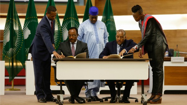Ethiopian government representative Redwan Hussein (second left) and Tigray People's Liberation Front (TPLF) representative Getachew Reda (second right) sign a peace agreement during a press conference regarding the African Union-led negotiations to resolve conflict in Ethiopia, in Pretoria on November 2, 2022.