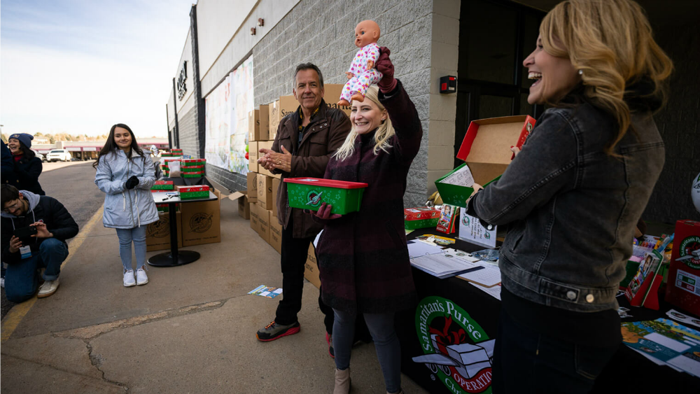 Elizabeth Groff packs a doll in a shoebox for Operation Christmas Child.
