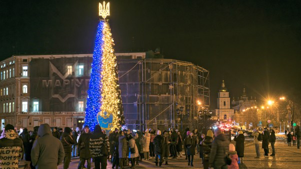 People take photos the Christmas tree at the Sofiyska Square after a Russian drone attack on Ukrainian power infrastructure early morning in Kyiv, Ukraine, on December 19, 2022.