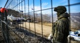 A Russian peacekeeper guards the Lachin corridor as Azerbaijani environmental activists protest against what they claim the illegal mining.