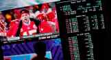 A person gambles at a Vegas casino in February as betting odds for NFL football's Super Bowl are displayed on monitors.