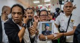 Rosti Simanjuntak (center), mother of late Brigadier Yosua Hutabarat, holds a picture of her son after former head of the internal affairs for Indonesia's national police Ferdy Sambo was sentenced to death during a verdict hearing in Jakarta.