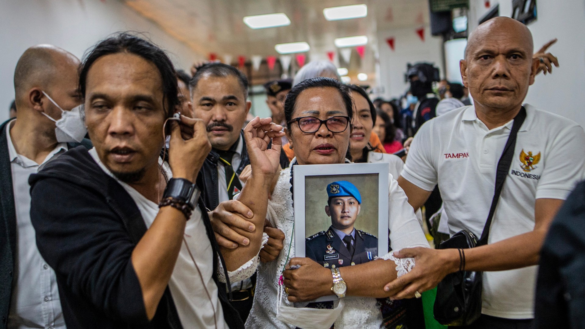 Rosti Simanjuntak (center), mother of late Brigadier Yosua Hutabarat, holds a picture of her son after former head of the internal affairs for Indonesia's national police Ferdy Sambo was sentenced to death during a verdict hearing in Jakarta.