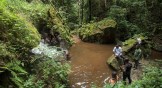 Men look at a waterfall in a protected Ghana forest. Environmental campaigners want the government to abandon plans to mine bauxite in the Atewa Range Forest Reserve.