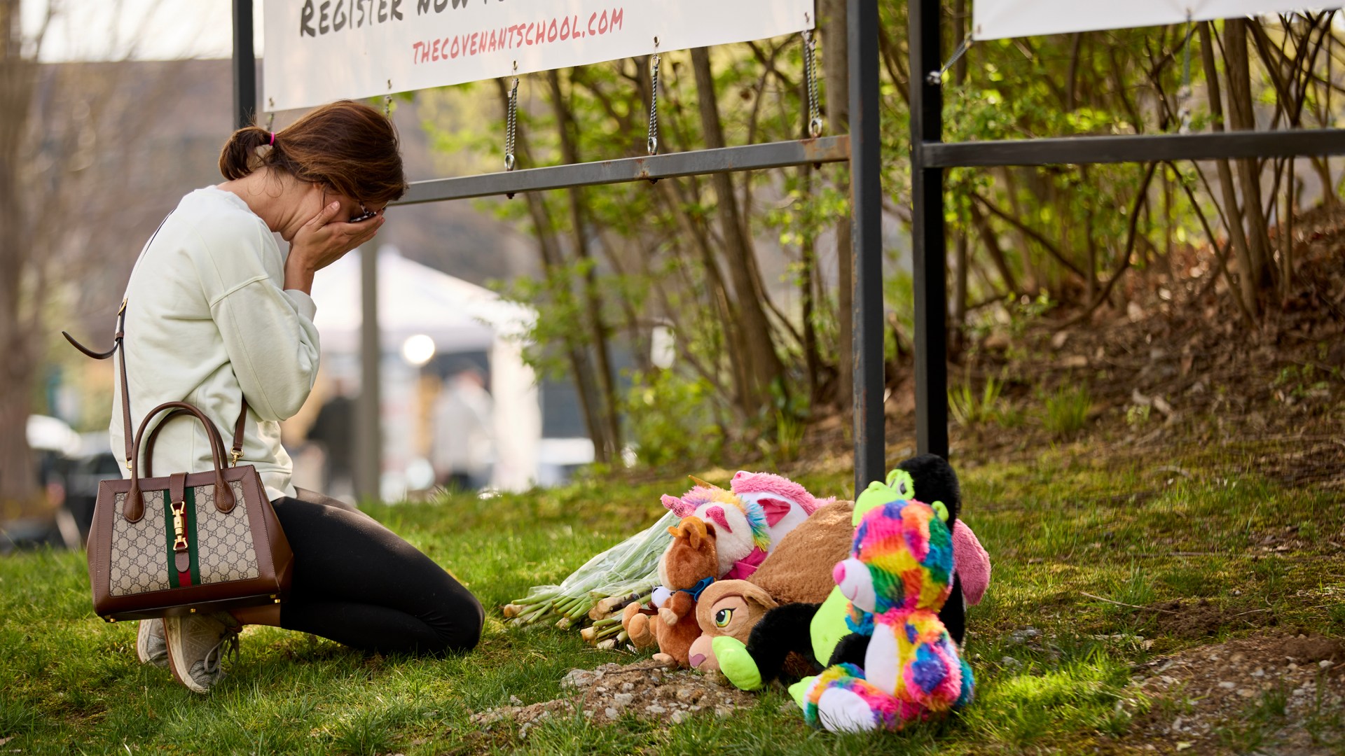 A woman cries as she leaves flowers at the Memorial held at The Covenant School after the shooting in Nashville, Tennessee.