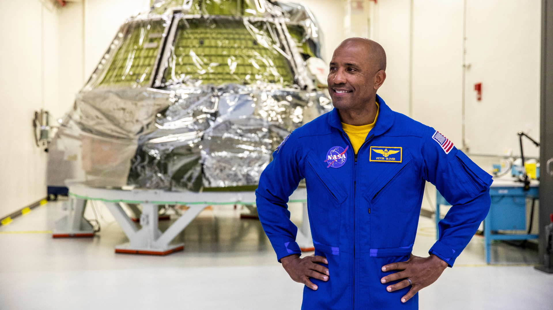 Astronaut Victor Glover stands in front of the Orion capsule that he will pilot around the moon as part of the Artemis 2 mission.